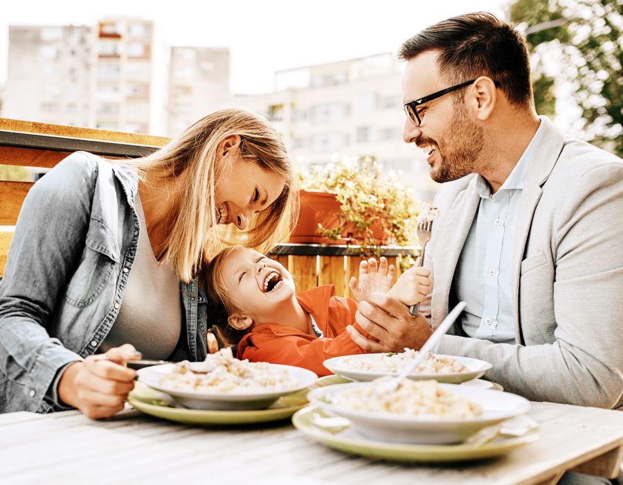 Happy family is enjoying pasta in restaurant.