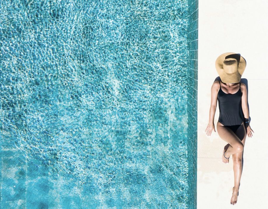Woman laying poolside next to outdoor pool